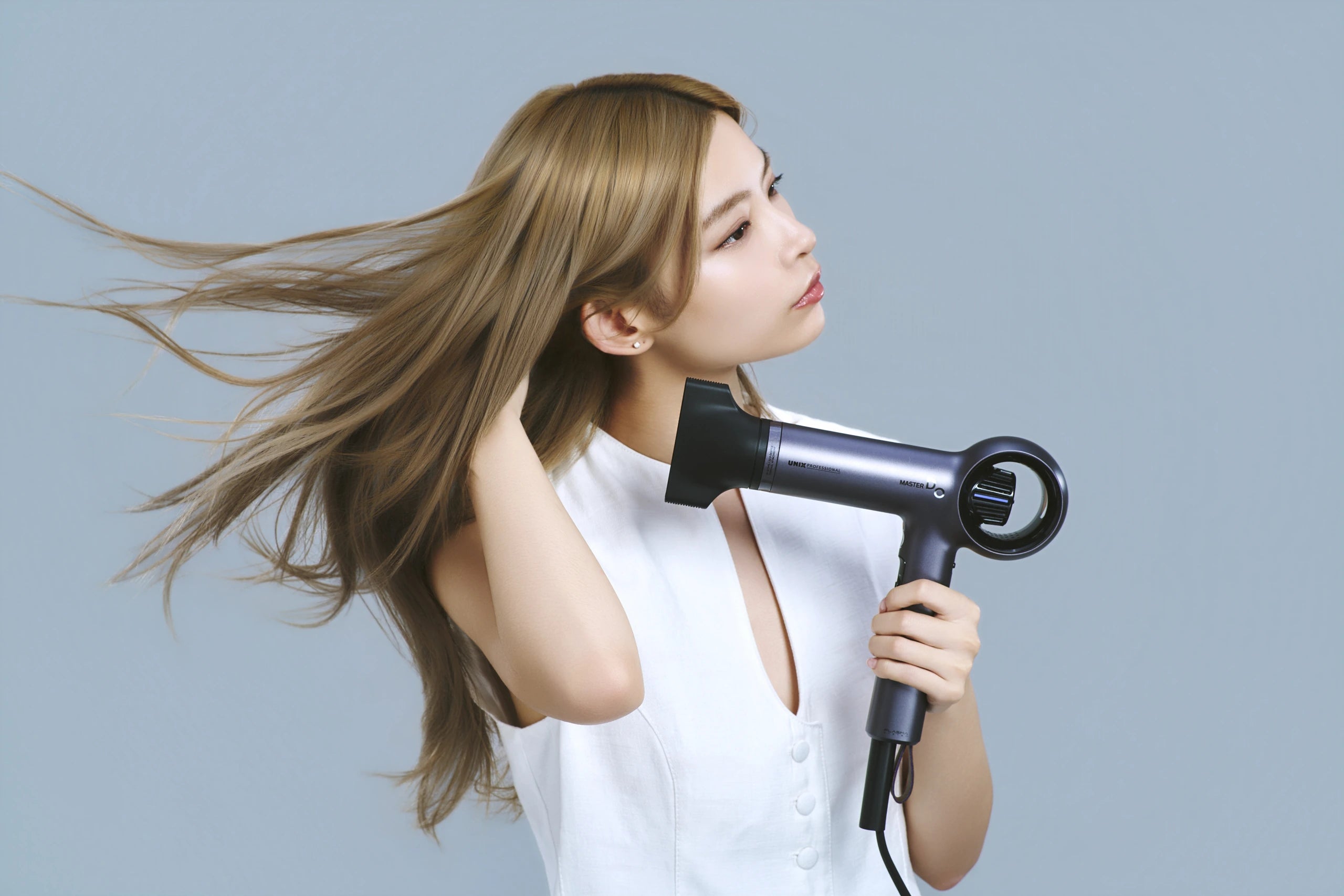 MASTER DOを手に、風でロングヘアが大きくなびくモデル