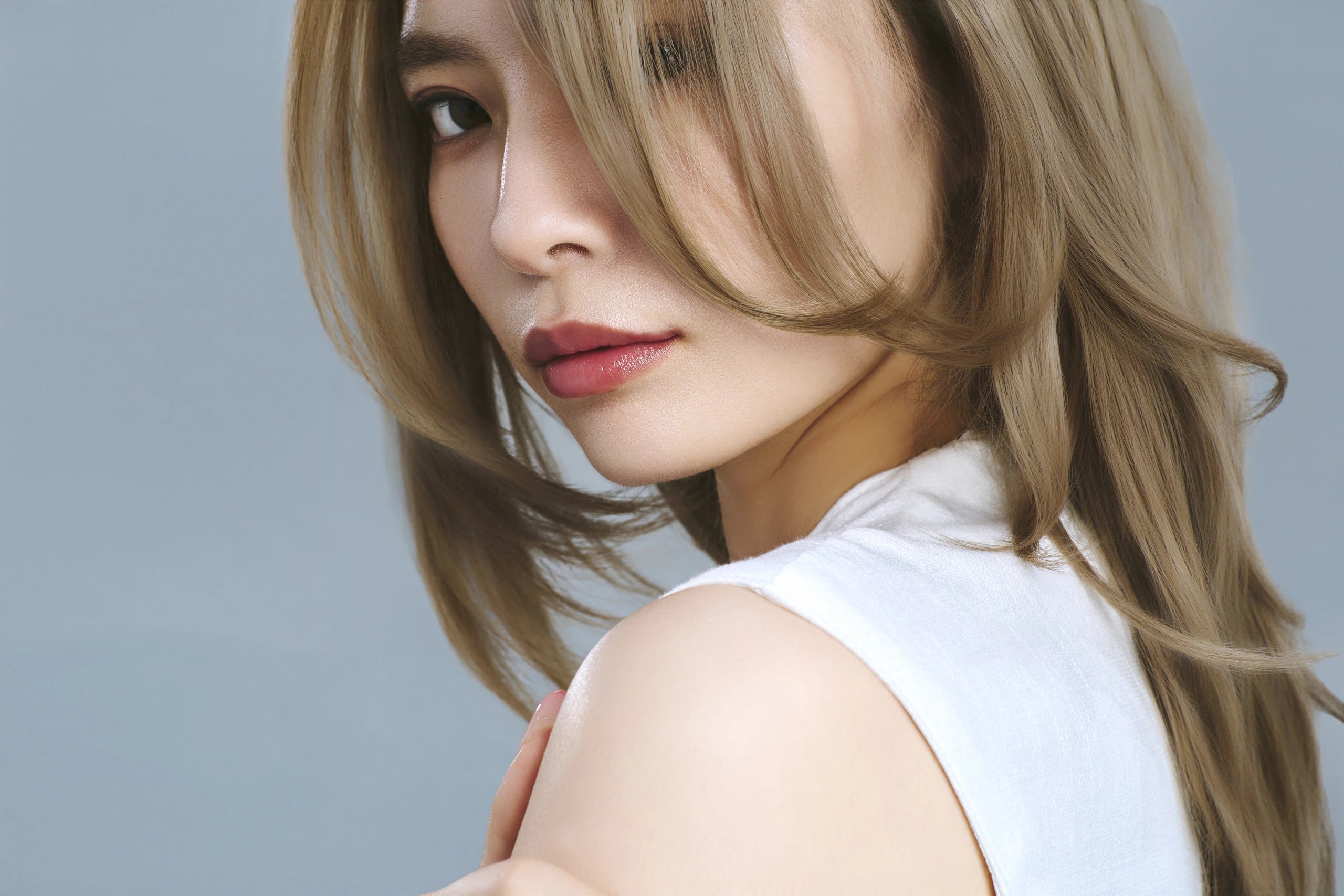 顔まわりと毛先にやわらかなカールをつけたヘアスタイル