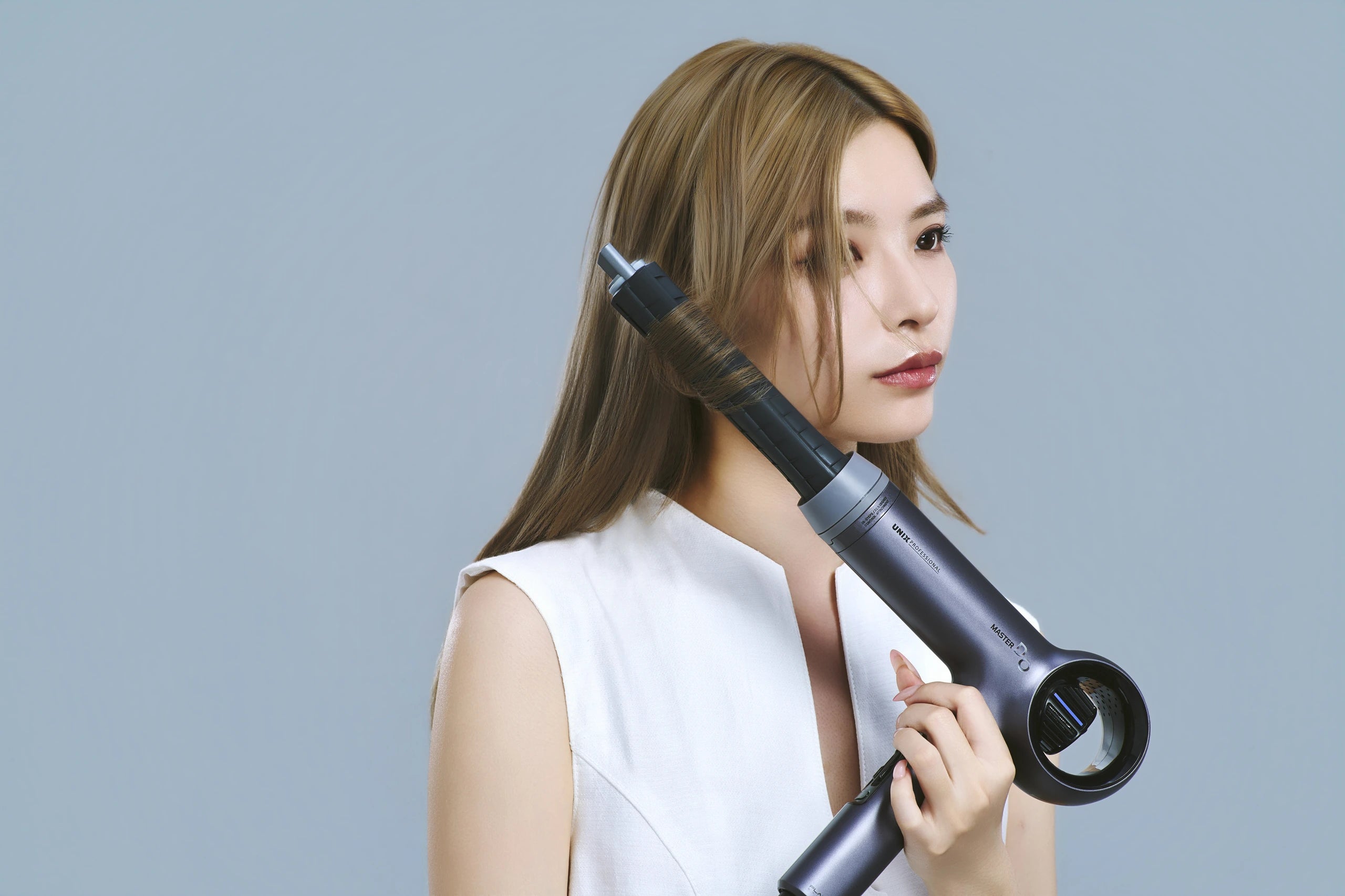 DUAL MOTION BARRELに顔まわりの髪を巻き付けてスタイリングする様子